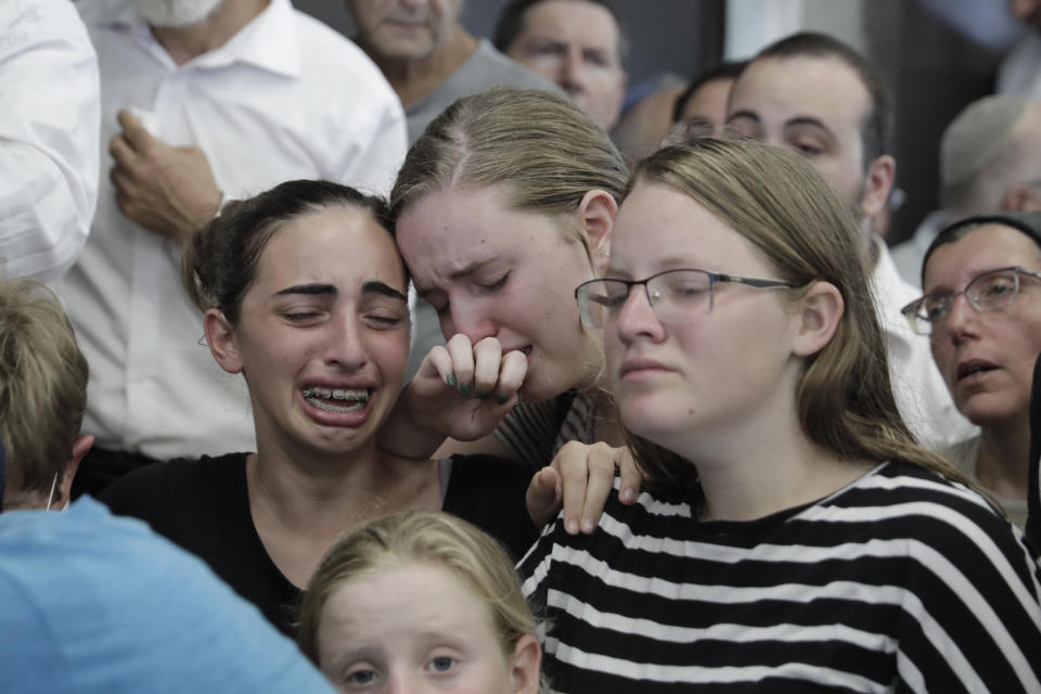 People attend the funeral of 17 year old Rina Shnerb, in Lod, Israel, Friday, Aug. 23, 2019. Shnerb has died of wounds from an explosion in the West Bank that the Israeli military has described as a Palestinian attack. (AP Photo/Sebastian Scheiner)