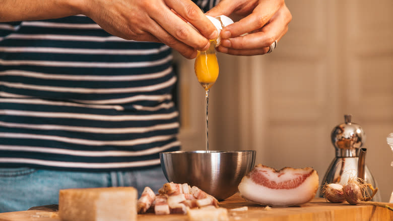 A person cracking an egg into a bowl