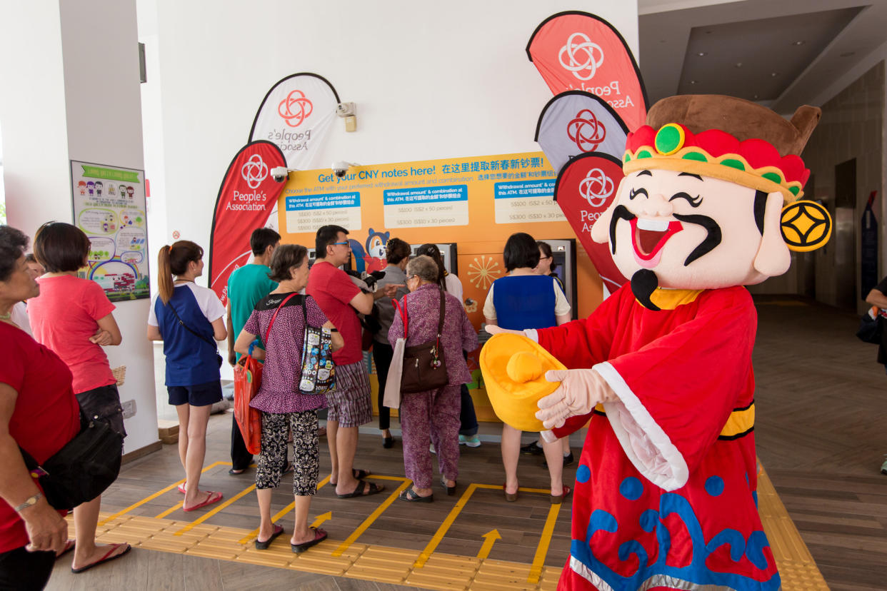 Customers withdraw new and good-as-new notes at a few of the 36 POSB new notes pop-up ATMs located in 27 community clubs in Singapore. (Photo: DBS)