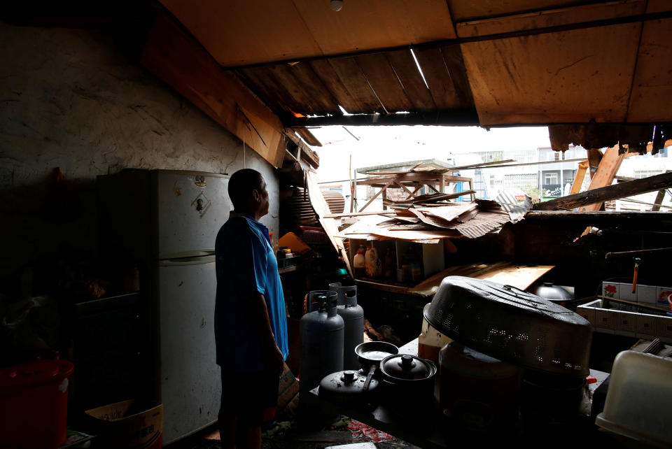 A man looks through a damaged rooftop