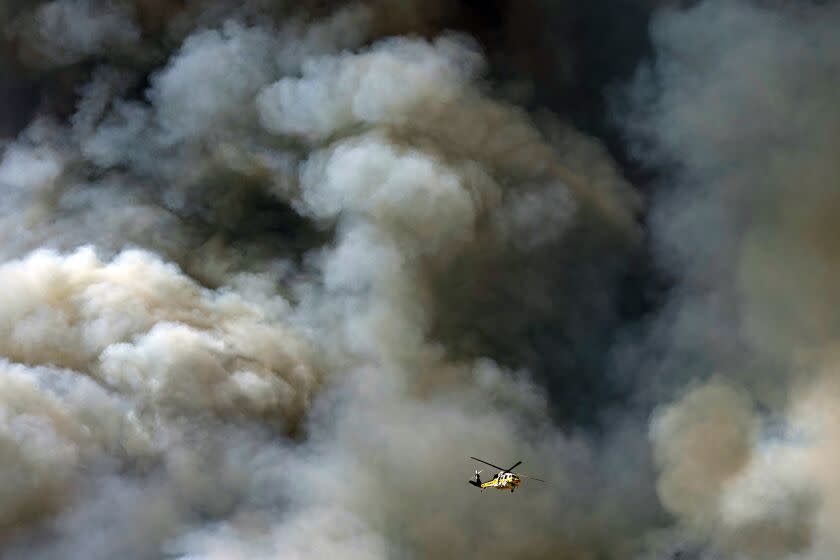 A helicopter flys over the advancing Route Fire over the closed-off interstate 5 Wednesday, Aug. 31, 2022, in Castaic, Calif. (AP Photo/Marcio Jose Sanchez)