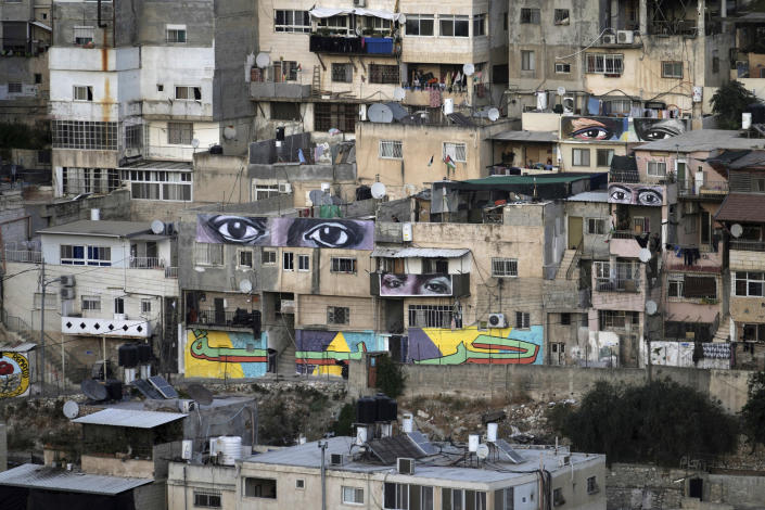 Murals that are part of the public art project 'I Witness Silwan' depicting the eyes of local and international figures, including George Floyd, a Black American killed by police, top right, in the Silwan neighbourhood of east Jerusalem, Friday, Aug. 26, 2022. Eyes are always open in this flashpoint district. Now, new eyes emerged; they were painted on the walls of the decaying Palestinian homes. The eye murals, and graffiti of Palestinian symbols, are so giant that make you feel they are watching you wherever you walk in the neighborhood. (AP Photo/ Mahmoud Illean)