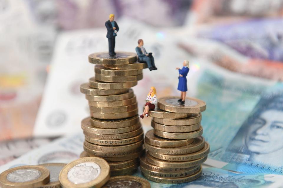 File photo dated 12/09/18 of models of men and women on a pile of coins and bank notes (Joe Giddens/PA) (PA Wire)