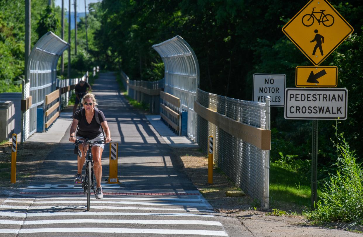 Cheryl Riebel, foreground, and her husband, Jeff, take a bike ride on the new Rock Island Greenway extension into Glen Oak Park. The extension included a complete renovation of the old railroad trestle over War Memorial Drive near the McClugage Bridge.