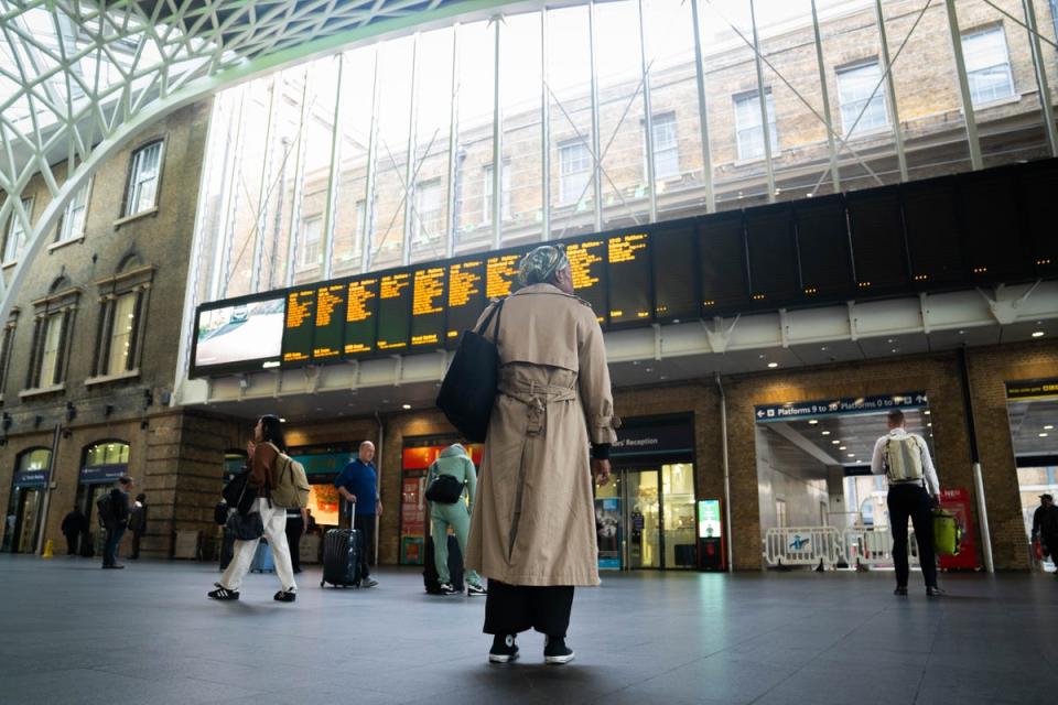 Passengers look at the departure board at Kings Cross station in London (File image) (PA Wire)