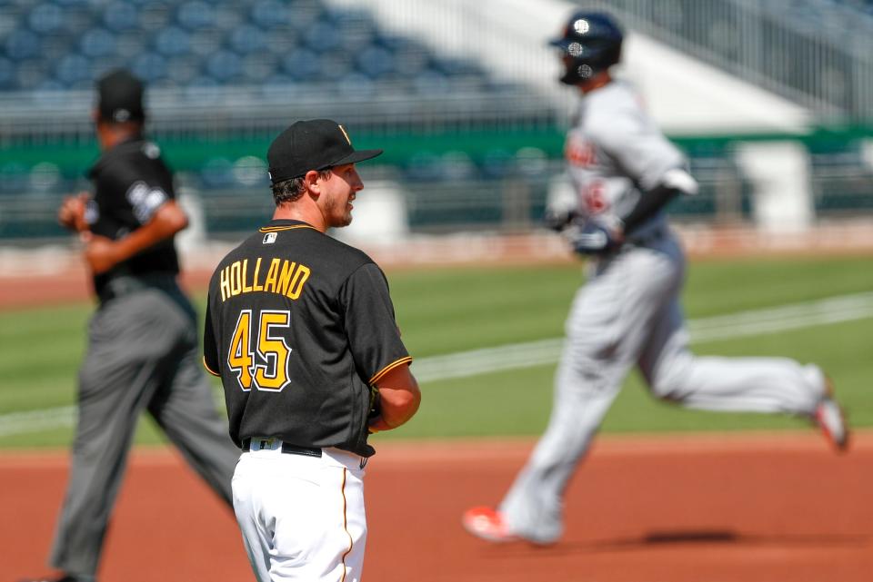 Tigers third baseman Jeimer Candelario, right, rounds the bases past Pirates pitcher Derek Holland with a home run in the first inning on Saturday, Aug. 8, 2020, in Pittsburgh.