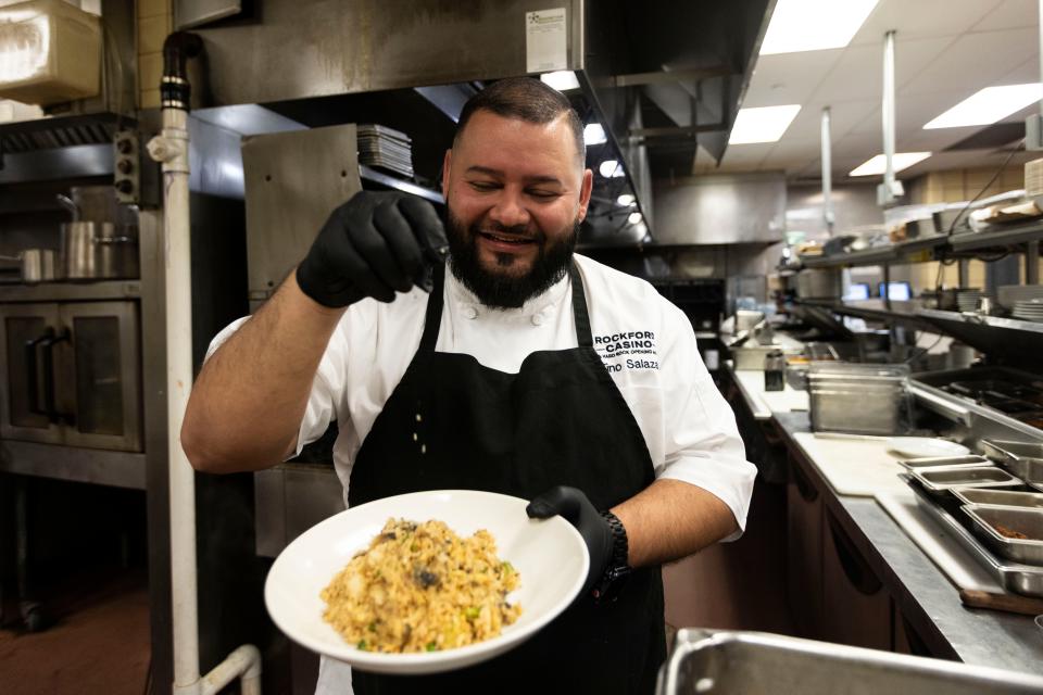 Hard Rock Casino Rockford Chef Juventino "Tino" Salazar sprinkles fried rice with sesame seeds in the Rockford Casino kitchen Feb. 28, 2024.