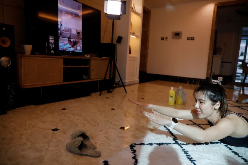 Zhang Weiya, a fitness trainer, teaches a livestreamed class at her house, as the country is hit by an outbreak of the new coronavirus, in Beijing