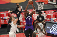 Toronto Raptors' OG Anunoby (3) dunks between Brooklyn Nets' Blake Griffin (2) and Kyrie Irving during the second half of an NBA basketball game Wednesday, April 21, 2021, in Tampa, Fla. (AP Photo/Mike Carlson)