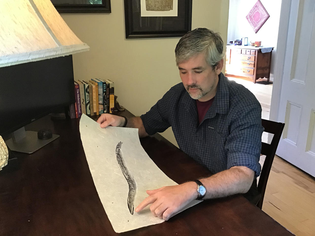 Greenlee looks at a gyotaku print of an eel by Bruce Koike