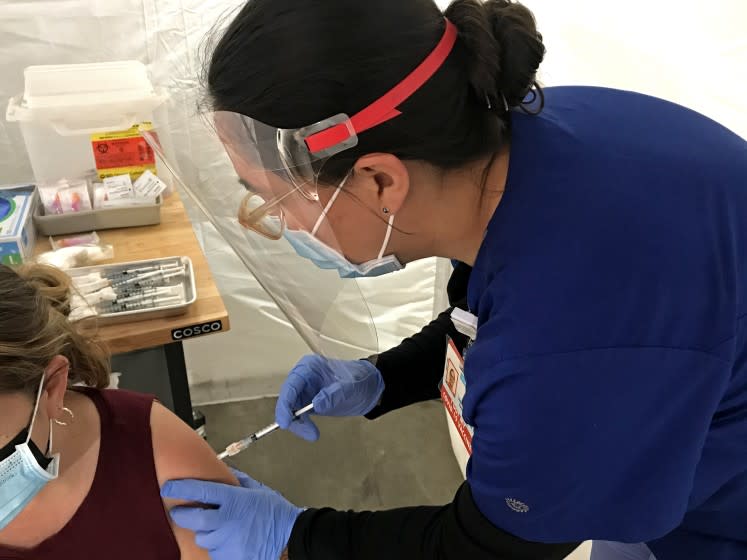 Anita Zamora administers a second shot of the Moderna vaccine to a patient at Venice Family Clinic on Feb. 20, 2021. (Robin Abcarian / Los Angeles Times)