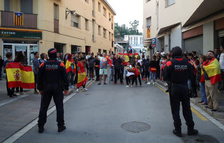 People who showed up to support the Spanish national police officers staying in town, hold up Spanish flags outside the police hotel in Pineda de Mar, north of Barcelona, Spain, October 3, 2017. REUTERS/Albert Gea