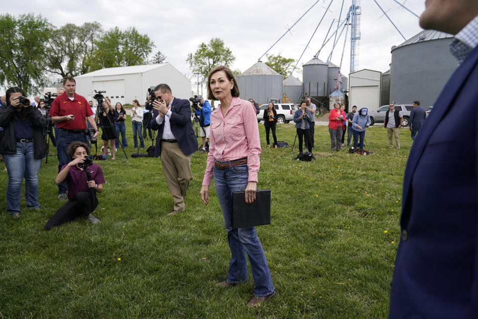 Iowa Gov. Kim Reynolds, center, arrives to sign the Biofuels Bill, Tuesday, May 17, 2022, in Prairie City, Iowa. (AP Photo/Charlie Neibergall)