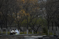 A worker in protective suit collects a sample from a woman at a coronavirus testing site setup inside a residential compound in Beijing, Thursday, Nov. 24, 2022. China is expanding lockdowns, including in a central city where factory workers clashed this week with police, as its number of COVID-19 cases hit a daily record. (AP Photo/Andy Wong)