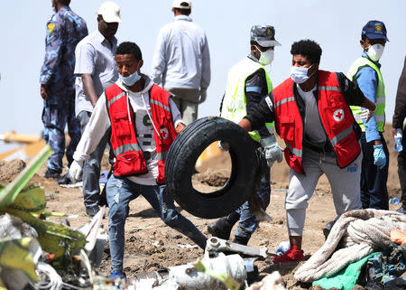 Search workers carry a tyre at the scene of the Ethiopian Airlines Flight ET 302 plane crash, near the town of Bishoftu, southeast of Addis Ababa, Ethiopia March 11, 2019. REUTERS/Tiksa Negeri/Files