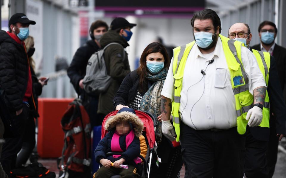 A family arriving at Edinburgh Airport from Turkey are escorted to a quarantine hotel on February 15 -  Getty Images Europe/Getty