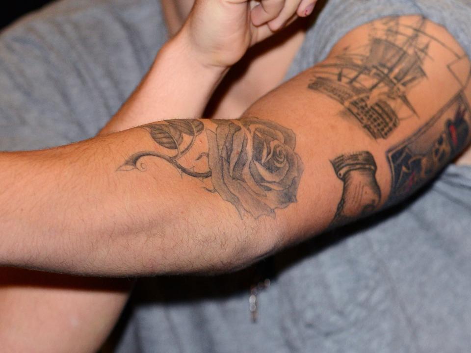 A large rose tattoo seen on Harry Styles' left arm.