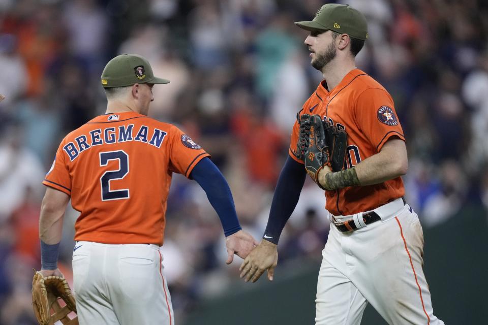 Houston Astros' Alex Bregman (2) and Kyle Tucker celebrate after a baseball game against the Oakland Athletics Friday, May 19, 2023, in Houston. The Astros won 5-1. (AP Photo/David J. Phillip)