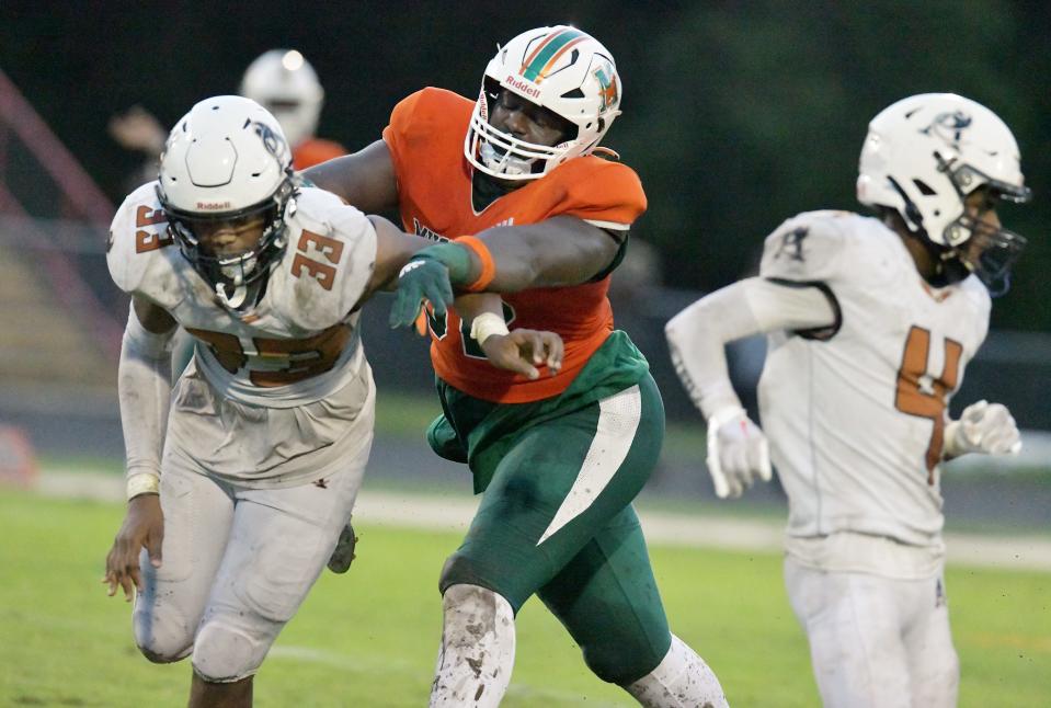 Mandarin's Deryc Plazz (52) gives Atlantic Coast Stingrays Xavier Wright (33) a shove during late second quarter action. The Atlantic Coast Stingrays traveled to Mandarin to play the Mustangs in High School football Friday, September 15, 2023.