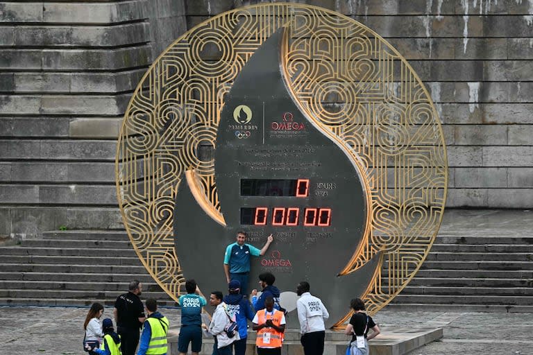 Un voluntario posa cerca del reloj de cuenta regresiva durante la ceremonia de apertura de los Juegos Olímpicos de París 2024