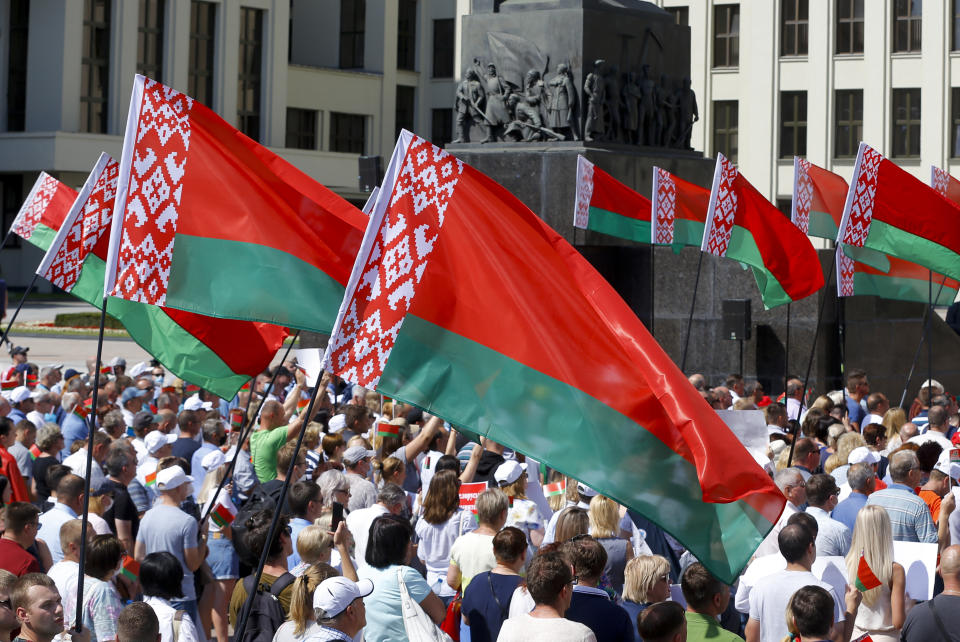 Thousands of supporters of Belarusian President Alexander Lukashenko with Belarusian State flags gather at Independent Square of Minsk, Belarus, Sunday, Aug. 16, 2020. Thousands of people have gathered in a square near Belarus' main government building for a rally to support President Alexander Lukashenko, while opposition supporters whose protests have convulsed the country for a week aim to hold a major march in the capital. (AP Photo/Sergei Grits)