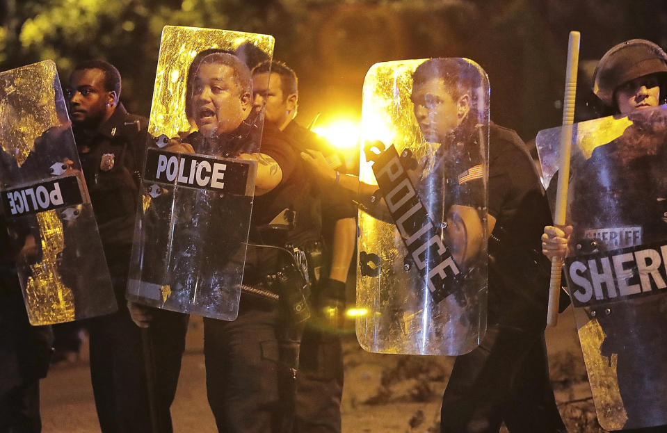 Memphis police brace against the crowd as protesters take to the streets of the Frayser community in anger against the shooting a youth by U.S. Marshals earlier in the evening, Wednesday, June 12, 2019, in Memphis, Tenn. (Jim Weber/Daily Memphian via AP)