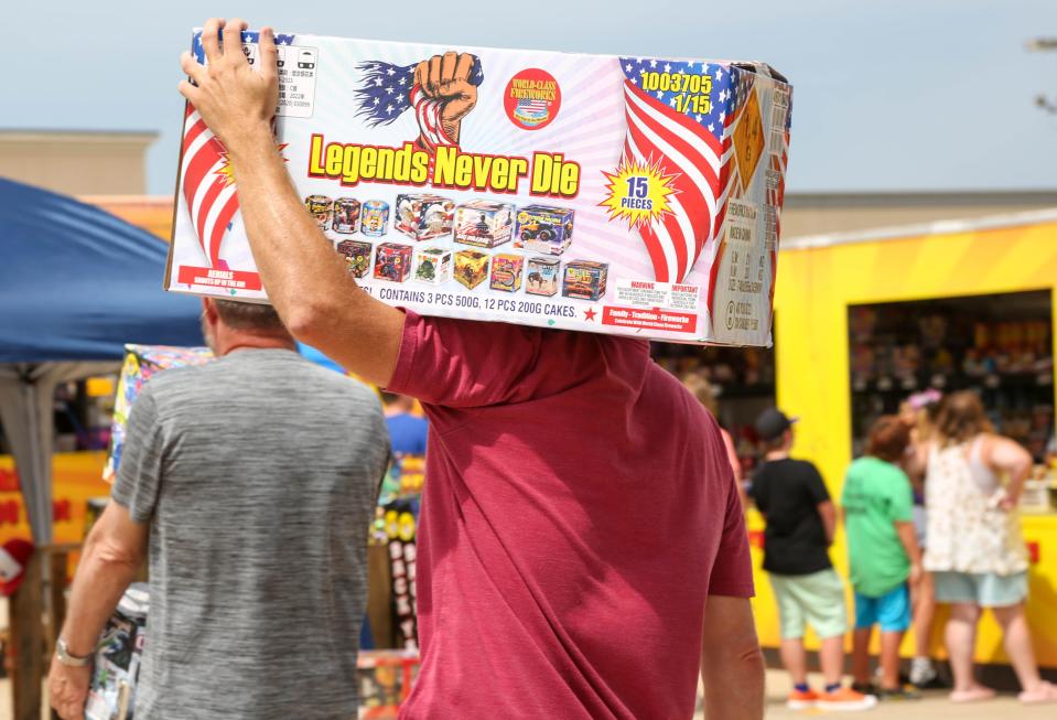 A man carries a firework pack named "Legends Never Die" at Jake's Fireworks stand in Mustang, Oklahoma on Monday, July 3, 2023.