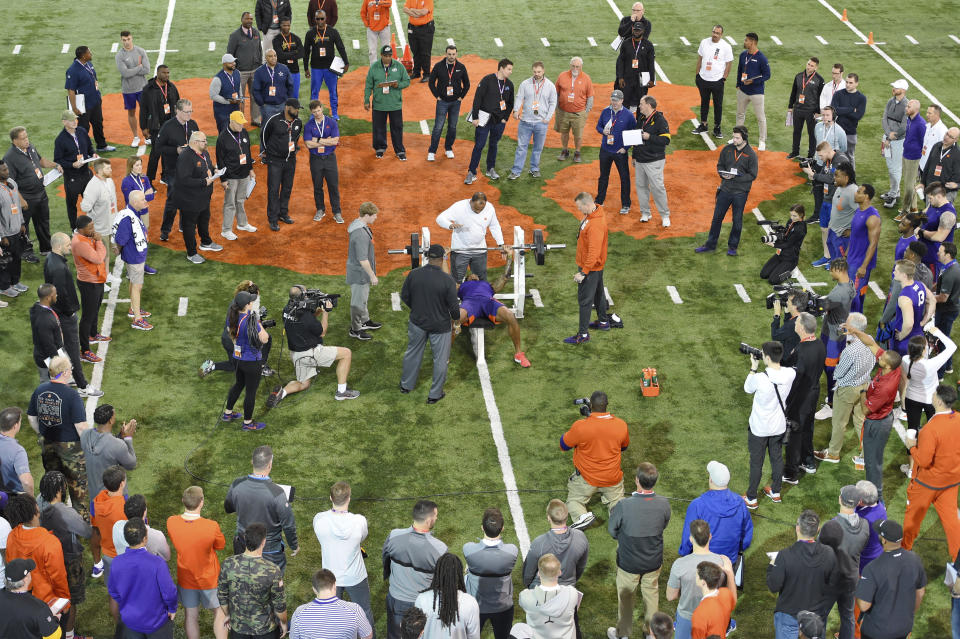 FILE - In this March 12, 2020, file photo, Clemson football player Tee Higgins lifts weights during NFL Pro Day in Clemson, S.C. Scouts, front-office executives and even coaches find themselves coping with a whole new process with Americans hunkering down and doctors overwhelmed by the mounting cases of COVID-19. Gone for the most part this year are access to in-person interviews, campus workouts and visits to team headquarters. (AP Photo/Richard Shiro, File)