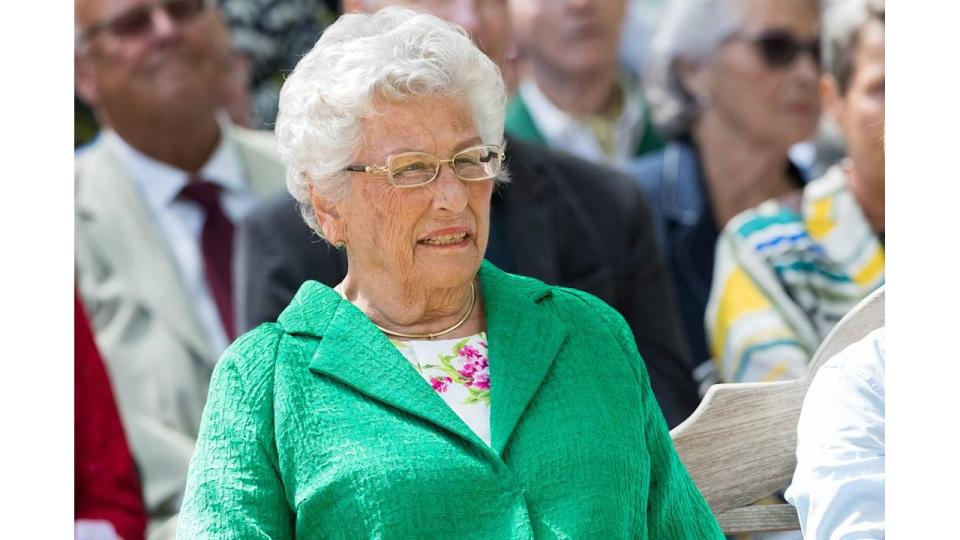 Princess Astrid sitting at a service in a green coat