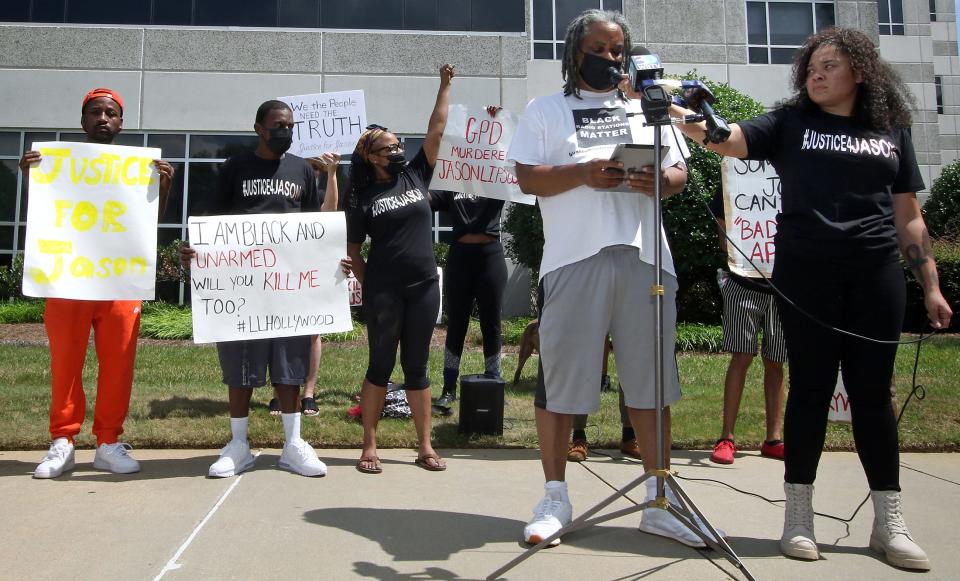 Scotty Reid reads a prepared statement as he and others gathered across from the Gaston County Courthouse Friday afternoon to express their feeling about the death of Jason Lipscomb.