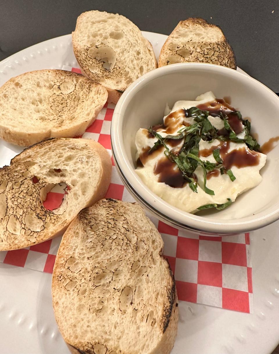 Honey and ricotta, topped with a reduced balsamic drizzle and basil, and served with charred slices of Italian bread, is one of the unique appetizer offerings at Maisano's Little Italian Kitchen in Plain Township.