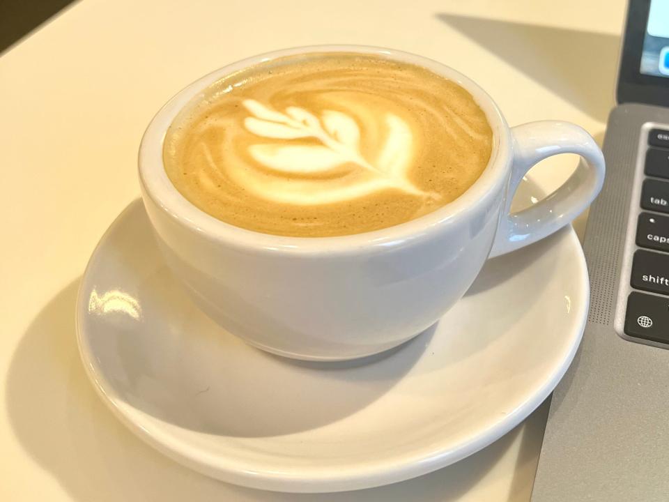 latte in a white ceramic cup on a table in a coffee shop