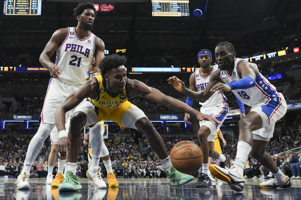 Indiana Pacers forward Aaron Nesmith (23) goes for the ball in front of Philadelphia 76ers guard Shake Milton (18) during the first half of an NBA basketball game in Indianapolis, Saturday, March 18, 2023. (AP Photo/AJ Mast)