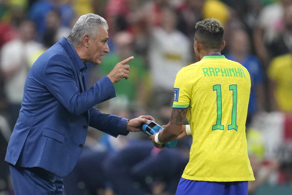 Brazil's head coach Tite, left, talks to Brazil's Raphinha during the World Cup group G soccer match between Brazil and Serbia, at the Lusail Stadium in Lusail, Qatar, Thursday, Nov. 24, 2022. (AP Photo/Natacha Pisarenko)