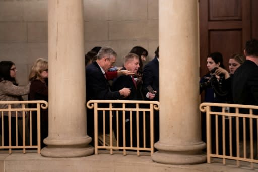 Senator Lindsey Graham walks with reporters after a meeting with Republicans about calling impeachment witnesses, but he said the president's trial "needs to end, end now"