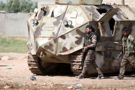 Fighters of the People's Protection Units (YPG) walk with their weapons in the city of Qamishli, Syria April 21, 2016. REUTERS/Rodi Said