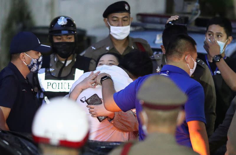 Parit Chiwarak is escorted after being arrested at the police station in Bangkok