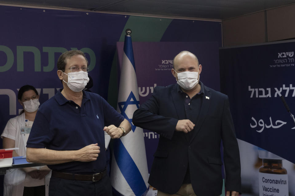Israeli President Isaac Herzog left, bumps elbows with Prime Minister Naftali Bennett after he received a third coronavirus vaccine injection at Sheba Medical Center in Ramat Gan, Israel, Friday, July 30, 2021. (AP Photo/Maya Alleruzzo, Pool)