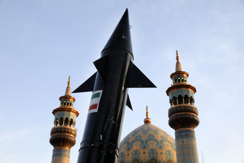 A model of a missile is carried by Iranian demonstrators as minarets and dome of a mosque is seen at background during an anti-Israeli gathering at the Felestin (Palestine) Sq. in Tehran, Iran, Monday, April 15, 2024. World leaders are urging Israel not to retaliate after Iran launched an attack involving hundreds of drones, ballistic missiles and cruise missiles. (AP Photo/Vahid Salemi)