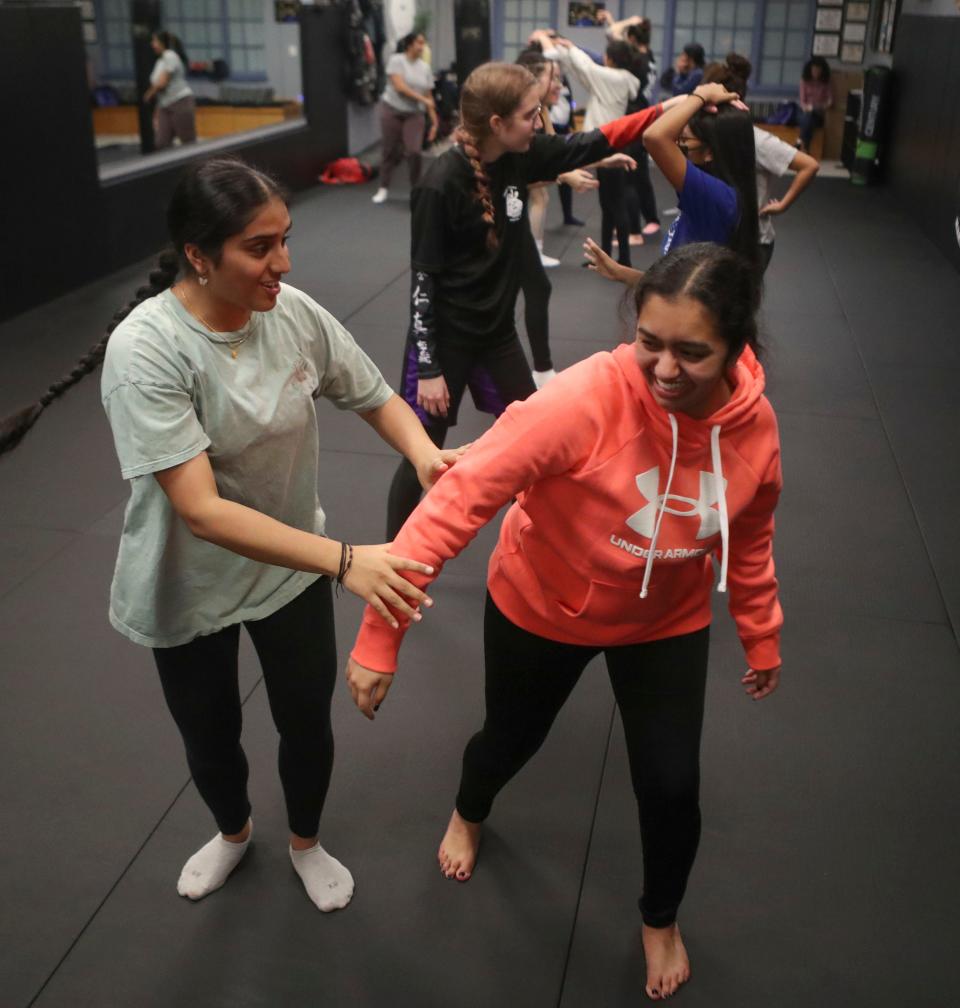 Tejasui Dantu, left, and Sanya Singh, both of Garnet Valley, Pa., take turns playing the role of an attacker as Girls Unite for Defense members take self-defense training at Delaware Dragon Martial Arts in Newark.