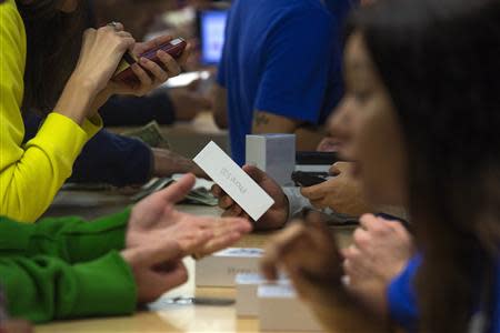 Customers purchase the iPhone 5s at the Apple retail store on Fifth Avenue in Manhattan, New York September 20, 2013. Apple Inc's newest smartphone models hit stores on Friday in many countries across the world, including Australia and China. REUTERS/Adrees Latif