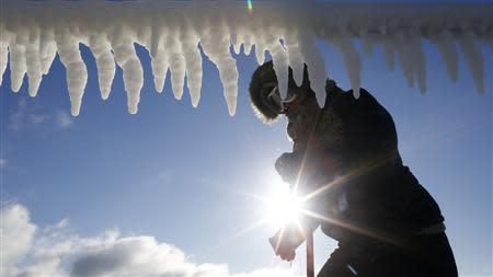 A woman is seen by icicles hanging from a breakwater along a beach in Chicago, Illinois, January 21, 2014. REUTERS/Jim Young