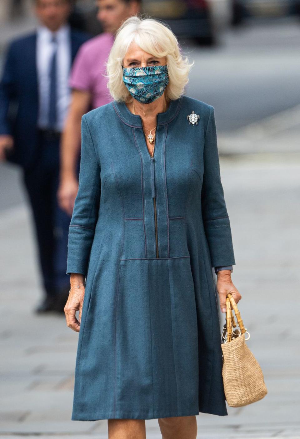 <p>For her first inside engagement since the coronavirus hit the UK, Camilla paired a blue dress with a turtle-shaped brooch and<a href="https://www.townandcountrymag.com/society/tradition/g32616136/queen-elizabeth-princess-charlotte-royal-family-liberty-of-london-print-photos/" rel="nofollow noopener" target="_blank" data-ylk="slk:a Liberty print mask.;elm:context_link;itc:0;sec:content-canvas" class="link "> a Liberty print mask.</a></p>