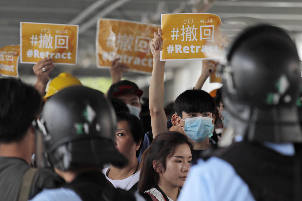 Riot police surround protesters near the Legislative Council in Hong Kong, Thursday, June 13, 2019. After days of silence, Chinese state media is characterizing the largely peaceful demonstrations in Hong Kong as a "riot" and accusing protesters of "violent acts." (AP Photo/Kin Cheung)