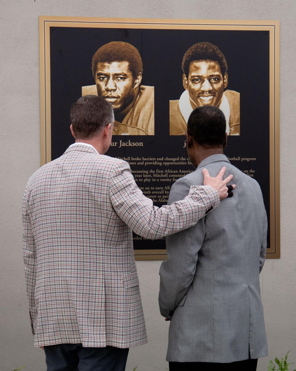 The University of Alabama honored its first two Black scholarship athletes, Wilbur Jackson and John Miitchell before the A-Day game on April 16, 2022, at Bryant-Denny Stadium. University of Alabama athletic director Greg Byrne stands with John Mitchell as they look at the new plaque that was unveiled.