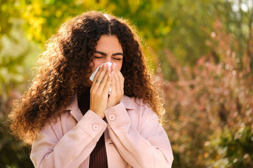 Young woman sneezing