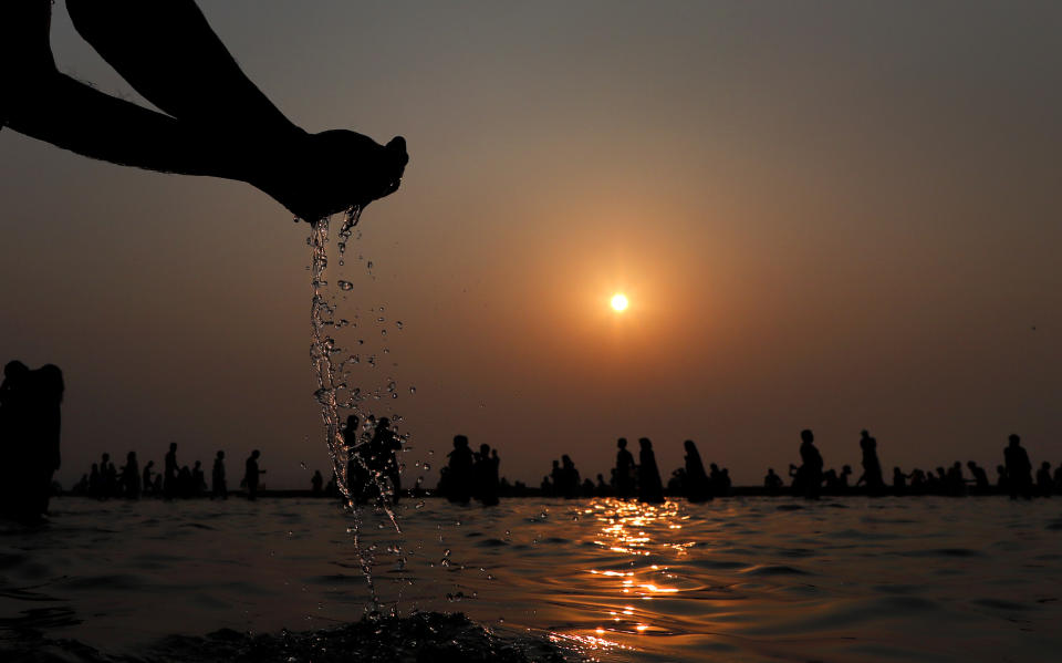 Pilgrims take holy dips early morning at Sangam, the sacred confluence of the rivers Ganga, Yamuna and the mythical Saraswati, during Magh Mela festival, in Prayagraj, India. Tuesday, Feb. 16, 2021. Hindus believe that ritual bathing on auspicious days can cleanse them of all sins. A tented city for the religious leaders and the believers has come up at the sprawling festival site with mounted police personnel keeping a close watch on the activities. The festival is being held amid rising COVID-19 cases in some parts of India after months of a steady nationwide decline. (AP Photo/Rajesh Kumar Singh)