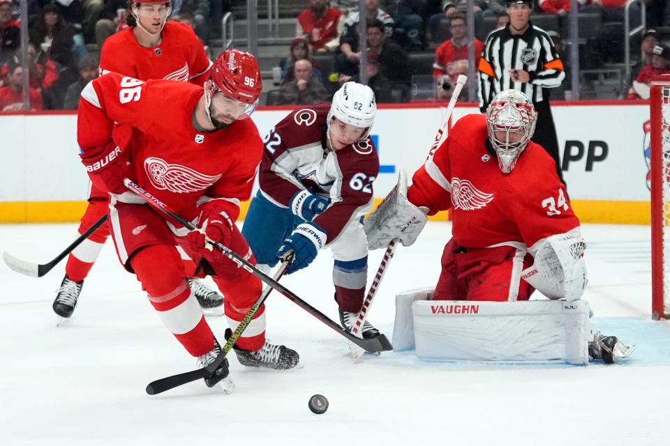 Detroit Red Wings defenseman Jake Walman (96) and Colorado Avalanche left wing Artturi Lehkonen (62) battle for the puck as goaltender Alex Lyon (34) looks on in the third period at Little Caesars Arena in Detroit on Thursday, Feb. 22, 2024.