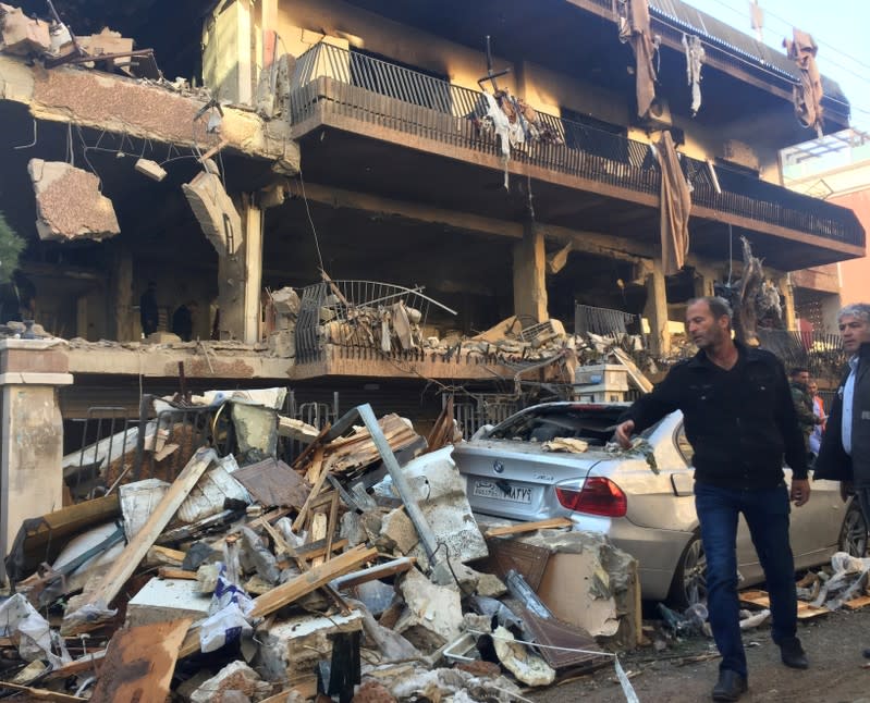 A man walks past a damaged building in Mezzah