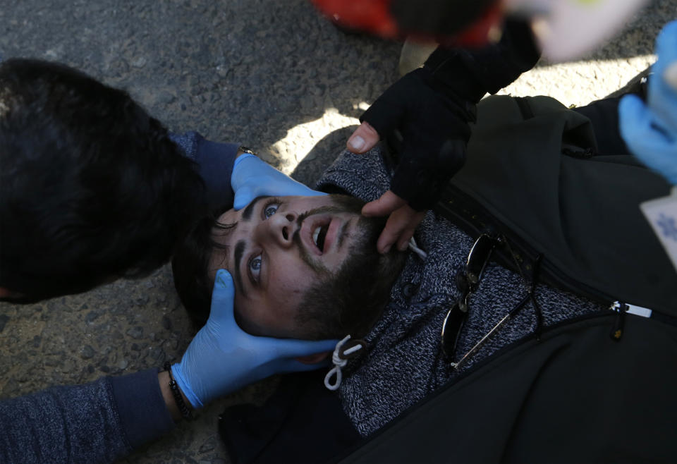 Civil defense workers treat an injured protester during scuffle between police and anti-government protesters in downtown Beirut, Lebanon, Monday, Jan. 27, 2020. Lebanese security forces scuffled Monday with protesters near the parliament building in downtown Beirut where lawmakers are scheduled to begin a two-day discussion and later approval of the budget amid a crippling financial crisis. (AP Photo/Bilal Hussein)